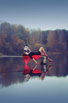 woman reading by a lake